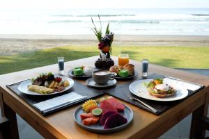 a table with four plates of breakfast food on it at Kelapa Retreat & Spa in Pulukan