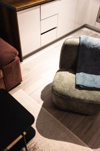 a living room with a couch and a chair at Blue Cozy Apartment in Pristina +25 photos