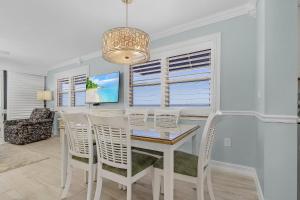 a dining room with a white table and chairs at Beach Villas 706 Top-Floor Condo with Gulf Views, Pool condo in Fort Myers Beach +17 photos