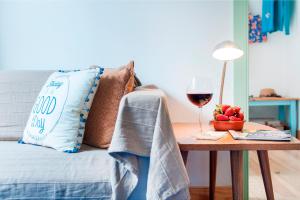 uma cama com uma mesa com um copo de vinho em Apartments in Historical Lisbon em Lisboa