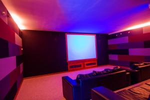 sala de estar con luces moradas y TV en Excelente Vista al Mar 84, en Concón