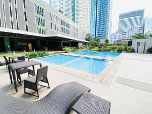 a patio with a table and chairs and a swimming pool at Avida Towers Riala - 2521 in Cebu City