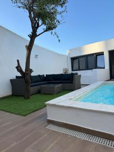 a backyard with a swimming pool and a tree at Casa Rosa in Setúbal