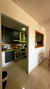 una cocina con armarios negros y amarillos y fregadero en Mar de Aguadulce AC, en Roquetas de Mar 11 fotos más