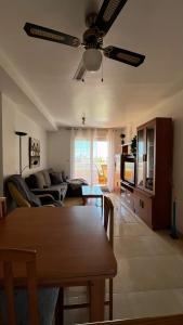 sala de estar con ventilador de techo y mesa en Mar de Aguadulce AC, en Roquetas de Mar