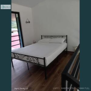 a bed in a room with a white mattress at Hermoso apartamento tipo loft in Nicoya