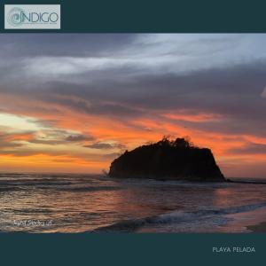 an island in the ocean with a sunset at Hermoso apartamento tipo loft in Nicoya