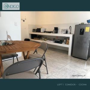 a kitchen with a wooden table and a refrigerator at Hermoso apartamento tipo loft in Nicoya