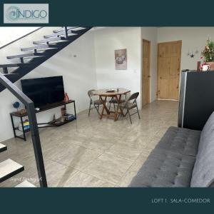 a living room with a table and a staircase at Hermoso apartamento tipo loft in Nicoya