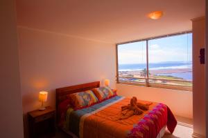 Un dormitorio con una cama con una ventana grande. en Excelente Vista al Mar 84, en Concón 40 fotos más