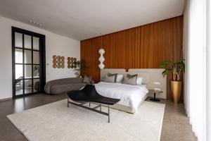 - une chambre avec un lit blanc et une chaise noire dans l'établissement Villa l'Hermitage, à Oulad Mbark