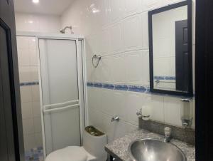 a bathroom with a toilet and a sink and a mirror at Casa amoblada in Apartadó