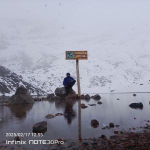 a person sitting on a rock next to a sign at Hotel Guajacum Riobamba in Riobamba +11 photos