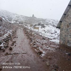 a dirt road in the snow with a pyramid in the background at Hotel Guajacum Riobamba in Riobamba