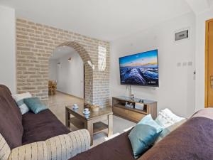 a living room with two couches and a flat screen tv at Apartment in Vodnjan with Pool & Jacuzzi in Vodnjan