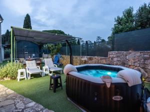 a hot tub in a yard with a table and chairs at Apartment in Vodnjan with Pool & Jacuzzi in Vodnjan
