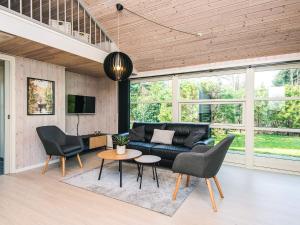 a living room with a black couch and chairs at 6 person holiday home in Ansager in Ansager