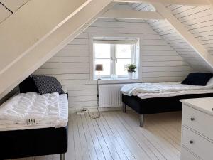 a attic room with two beds and a window at Cottage with Fjord View, Stenungsund in Stenungsund
