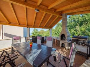 an outdoor patio with a table and a fireplace at Apartment in Drenje with Stunning Sea View in Drenje