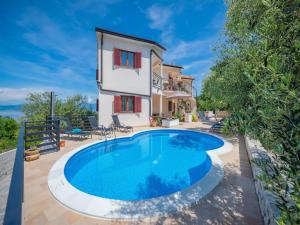 a villa with a swimming pool in front of a house at Apartment in Drenje with Stunning Sea View in Drenje