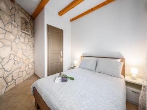a bedroom with a bed and a stone wall at Apartment in Drenje with Stunning Sea View in Drenje +12 photos