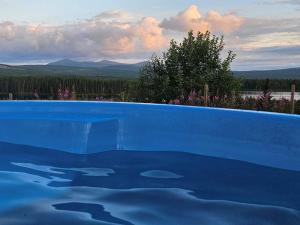 a blue swimming pool with a view of the mountains at 4 person holiday home in Föllinge in Föllinge