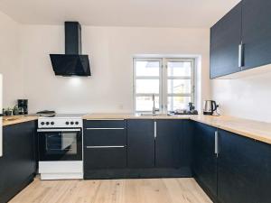 a kitchen with black cabinets and a white stove at 5 star holiday home in Liseleje in Liseleje +36 photos