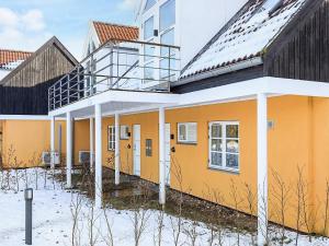 a yellow building with snow on the ground at 5 star holiday home in Liseleje in Liseleje