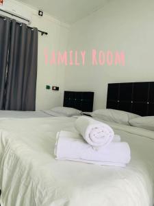 a white towel sitting on top of a bed at Green Forest Resort in Setiu