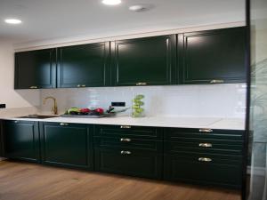 eine Küche mit dunkelgrünen Schränken und weißen Arbeitsplatten in der Unterkunft Villa in Sanxenxo with Pool & Sea Views in Pontevedra