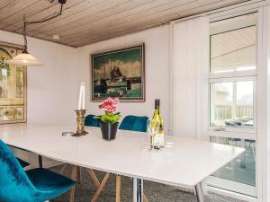 a dining room with a white table and blue chairs at 8 person holiday home in Ulfborg in Ulfborg