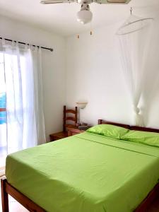 a bedroom with a green bed and a window at Beachapartment fully serviced in Sal Rei +32 photos