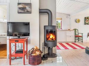 a fireplace in a living room with a tv at 5 person holiday home in Røros in Røros