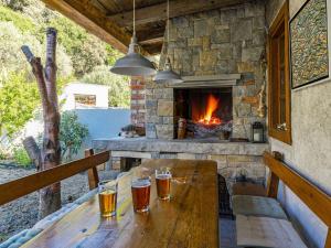 a wooden table with glasses of beer on it with a fireplace at Tranquil Escape in Banjol in Banjol