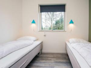 two beds in a room with a window at 4 star holiday home in Fårvang in Fårvang +27 photos