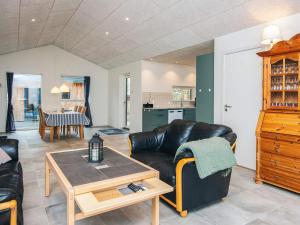 a living room with a leather couch and a table at 4 star holiday home in Fårvang in Fårvang