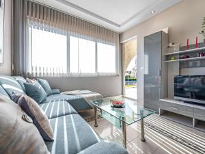 a living room with a blue couch and a glass table at Apartment near Rab Beach in Banjol