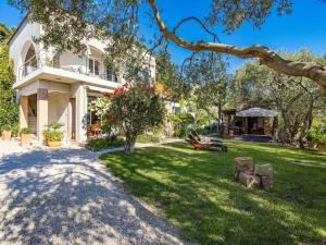 a large white house with a yard at Serene Studio by the Sea in Banjol