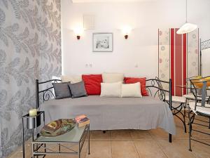 a bedroom with a bed with red pillows and a table at Serene Studio by the Sea in Banjol