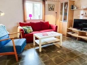 a living room with a red couch and a coffee table at 4 person holiday home in FäRJESTADEN in Färjestaden