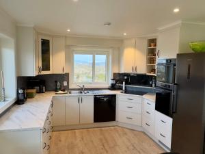 a kitchen with white cabinets and a black refrigerator at 4 star holiday home in Tjeldstø in Tjeldstø