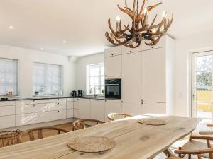 a kitchen with a wooden table and a chandelier at 5 star holiday home in Liseleje in Liseleje