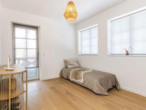 a bedroom with a bed and a table and windows at 5 star holiday home in Liseleje in Liseleje