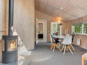 a living room with a fireplace and a table and chairs at 6 person holiday home in Sæby in Sæby