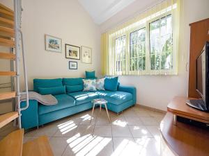 a living room with a blue couch and a window at Apartment with Garden, Banjol in Banjol