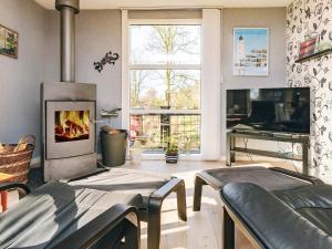 a living room with a fireplace and a tv at 4 person holiday home in Vordingborg in Vordingborg