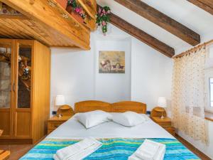 a bedroom with a large bed with wooden ceilings at Apartment in Cres with Sea View and Old Town in Cres