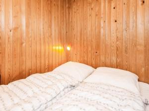 a bed in a room with wooden walls at 6 person holiday home in Fanø in Fanø