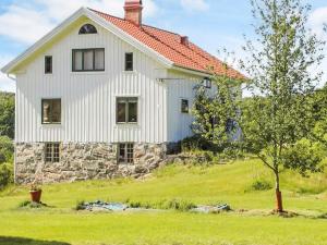 a white house on a hill with a tree at 4 star holiday home in UDDEVALLA in Fiskebäckskil