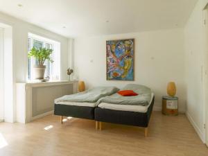Dybvadにある4 star holiday home in Dybvadの壁に絵が掛かっている部屋のベッド